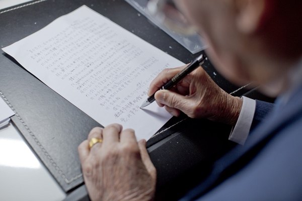close-up of Chang writing by hand